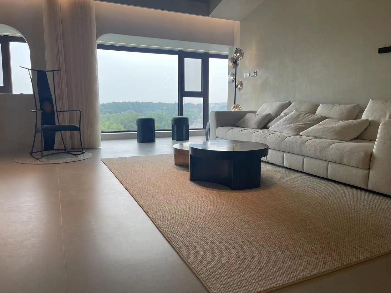 Curved blackened-steel coffee table on a sisal rug