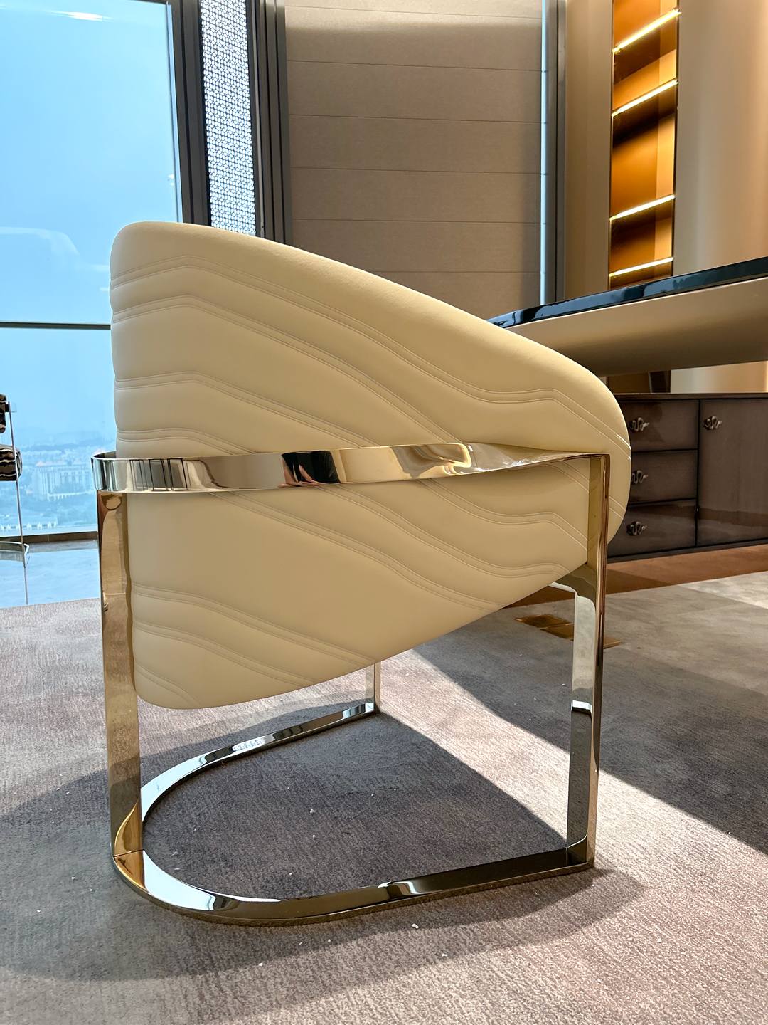 Armchair in cream leather with a polished brass frame