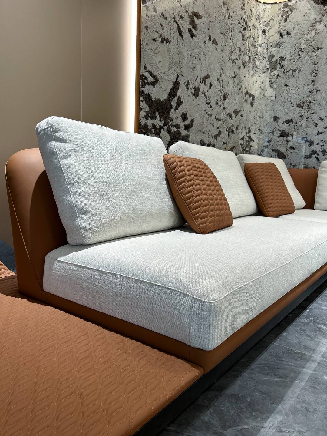Lounge sofa — tan leather shell, linen cushions